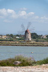 Sea saltworks, salt wind mills and pans, manually extracting high-quality salt, near Marsala and...