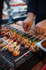 Grilled Skewers with Shrimp, Chicken, and Tomatoes on a BBQ Grill