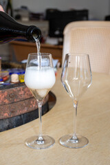 Pouring in glass of white sparkling wine brut, grand reserve, champagne in Ay-Champagne old grand cru wine making village in Vallee de la Marne, Champagne, France