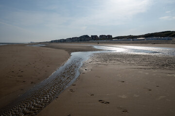 White sandy beach in cosy seaside holiday village on North Sea, built in belle epoque style in Flanders, De Haan or Le Coq sur Mer, Belgium
