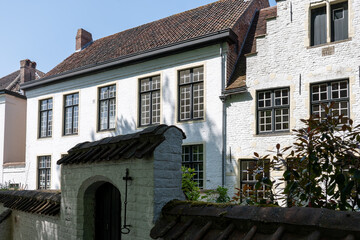 Medieval convent for nuns who weave lace in Bruges, Flanders, small white houses and a park inside the monastery walls, Belgium