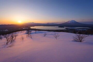 Pink sunrise over snowy peak and lake