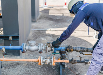 The technician is opening the valve to load the gas.