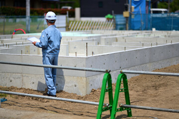 住宅建築の基礎を点検する工事監督