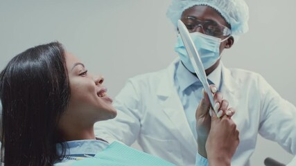 A skilled African American dentist engages with a patient in a dental clinic, demonstrating professionalism and care. The atmosphere is clean and equipped for effective treatment.