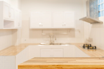 Empty wooden countertop table in modern white kitchen interior background with copy space for product display