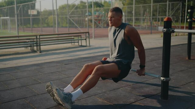 Athletic man performing tricep dips in an urban park setting. This outdoor workout scene captures fitness and determination, highlighting the benefits of outdoor physical activities.