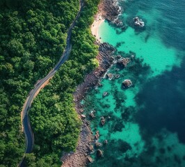 a winding road cutting through dense green forest along a rocky coastline with vibrant turquoise blue ocean waters and a small sandy beach