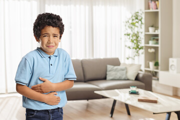 Kid with tummy ache in a living room