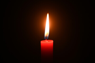 Close-up of a burning candle in a dark background