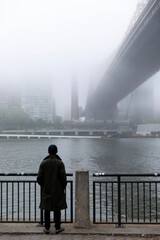 Person looking at the Queensboro Bridge covered in fog 