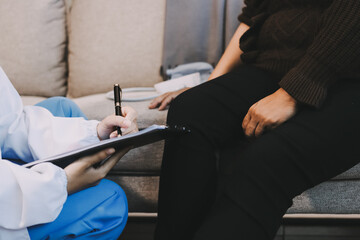 Young doctor examines senior patient's leg.