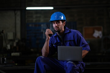 Fototapeta premium Portrait of foreman, engineer or architect with safety helmet holding laptop and blueprints for inspection details on factory industry material.