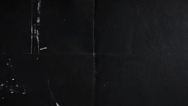 Distressed black paper texture, with folds, creases, and white scuff marks, dark and weathered surface providing vintage feel.