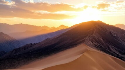 Majestic golden sunset over mountainous landscape with rolling sand dunes in foreground, creating a scenic panorama - Powered by Adobe