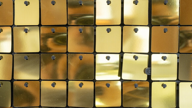 Gold reflective sequin squares arranged in a neat pattern, creating a stylish and festive backdrop ideal for luxury events, parties, or modern photo booth backgrounds.