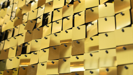 Golden metallic sequins arranged in a grid pattern with a reflective surface, creating a shimmering...