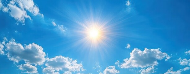 Bright sun shining in a clear blue sky scattered with white fluffy clouds creating a serene and uplifting atmosphere