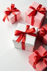 Obraz premium Several red ribbon tied Christmas gift boxes on a white table, box, christmas, christmastime