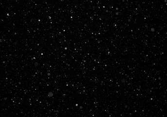 Fototapeta premium Falling snow creating a wintery and atmospheric effect on black background
