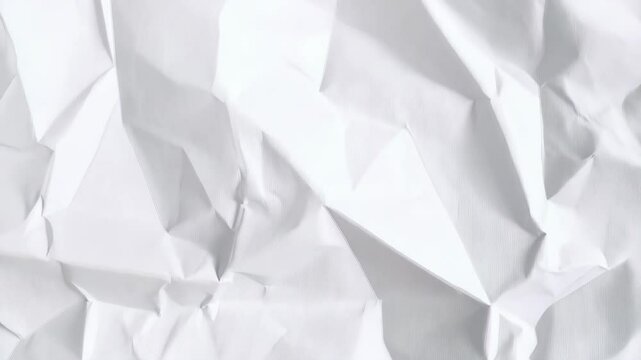 Extreme close up texture of a rumpled white paper sheet, showing folds and creases in high resolution, providing a neutral backdrop