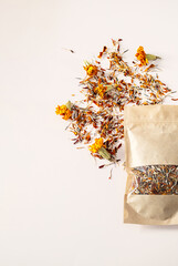Dried Marigold Petals and Whole Flowers Scattered Next To an Open Craft Paper Bag, Top View with Copy Space.