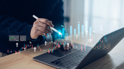 Business professional analyzing financial data on laptop with digital graphs and statistics...