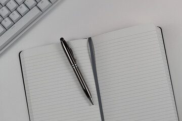 Work Desk Flat Lay with White Keyboard and Notepad