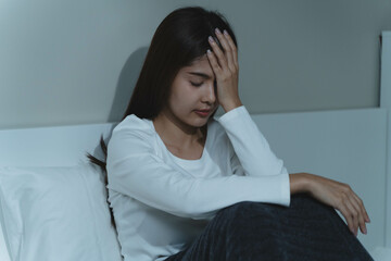 Young woman sleepless during night time on the bed.