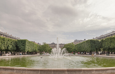 View of Fountain in the Jardin du Palais Royal with the Palais Royal building and sky in the backhground. known as "Fontaines de Pol Bury" use it as your Wallpaper, Poster and Space for text.