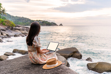 Young woman freelancer traveler working online using laptop while traveling on summer vacation, Freelance and workation concept