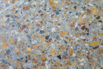 Close-up of a speckled terrazzo or mosaic floor, composed of various colored aggregate chips embedded in a lighter matrix. Represents patterns, textures, abstract backgrounds, construction materials