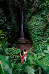 Young couple tourism enjoying the Leke Leke waterfall at Bali in Indonesia