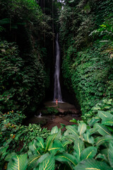 Young female tourism enjoying the Leke Leke waterfall at Bali in Indonesia