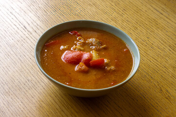 Bowl of Traditional Goulash Soup on Wooden Table – Hearty Meat, Peppers and Onion Stew.
