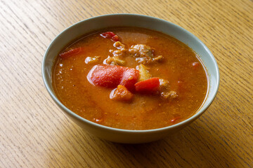 Bowl of Traditional Goulash Soup on Wooden Table – Hearty Meat, Peppers and Onion Stew.