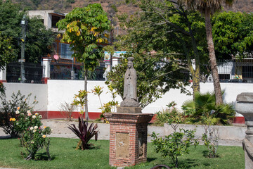 Obraz premium Ajijic, Mexico - January 26 2025: Stone statue in garden with trees and flowers in Ajijic, Jalisco, surrounded by peaceful greenery