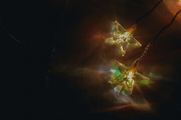 Fairy Lights on Fabric Background. Star garland and iridescent fabric.