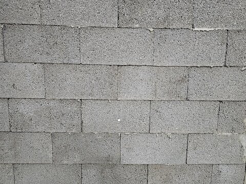 Concrete block wall with consistent texture pattern, showcasing construction materials and techniques in a building site environment