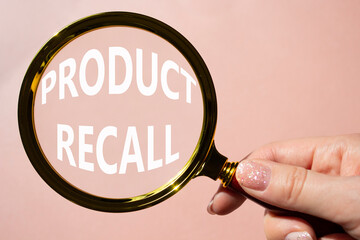 Product recall symbol. Concept words Product recall on magnifying glass. Beautiful pink background....