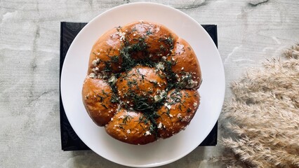 Fresh Ukrainian Garlic Pampushky with Dill on a White Plate