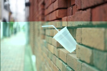 Plastic Cup Mockup with Straw Stuck in Brick Wall with Street View Background