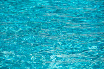 Water background, ripple waves. Blue swiming pool pattern. Sea surface. Water in swimming pool with sun reflection. Banner with copy space.