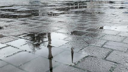 Reflections on wet pavement after a rain shower in the city