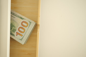 Money placed in a wooden drawer for safekeeping