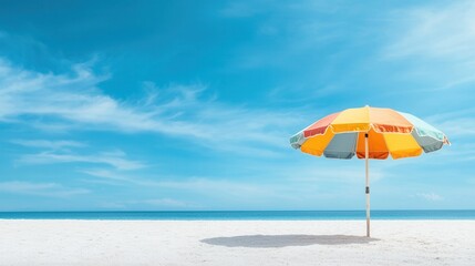 summer concept. A colorful beach umbrella on a sandy shore under a bright blue sky.