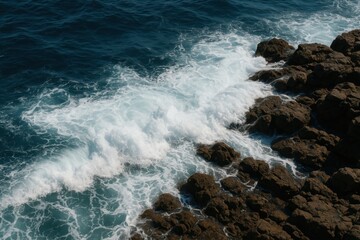 Fototapeta premium Waves Crashing on Rocks: The Dynamic Beauty of Ocean Foam and Rocky Shores for Artistic Realism