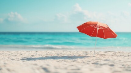 summer concept. Beach scene with a red umbrella and turquoise water in the background.