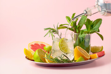 Cocktail with ice, citrus, rosemary and mint.