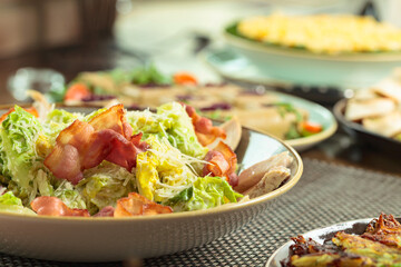 Salad with grilled bacon, hard cheese, tomato, and croutons.